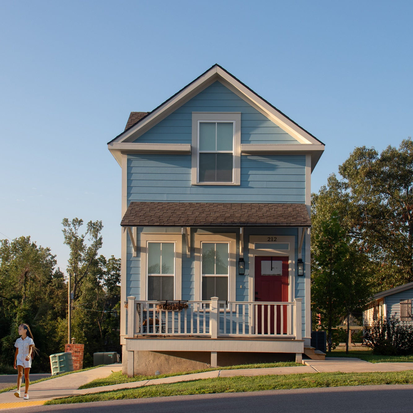 Blue house with a red door and front porch